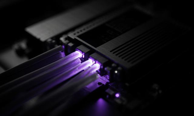 Close-up of industrial circuitry and fiber optics pulsing with light